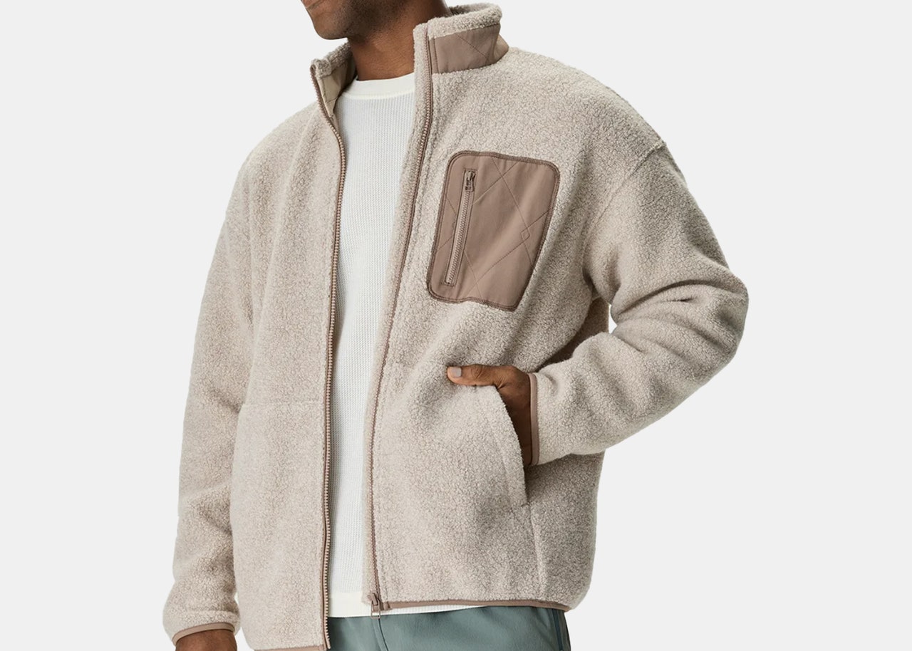 Cream fleece jacket with taupe breast pocket with zipper on male model.
