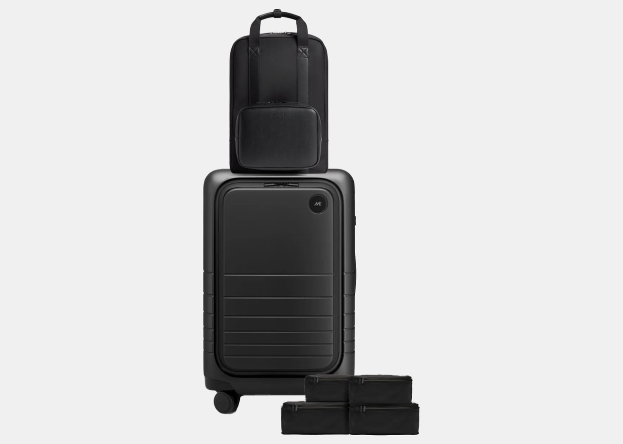 one black backpack, one rolling suitcase and four small black accessory bags